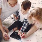 Parents and child enjoying drawing together on the floor, creating memories.